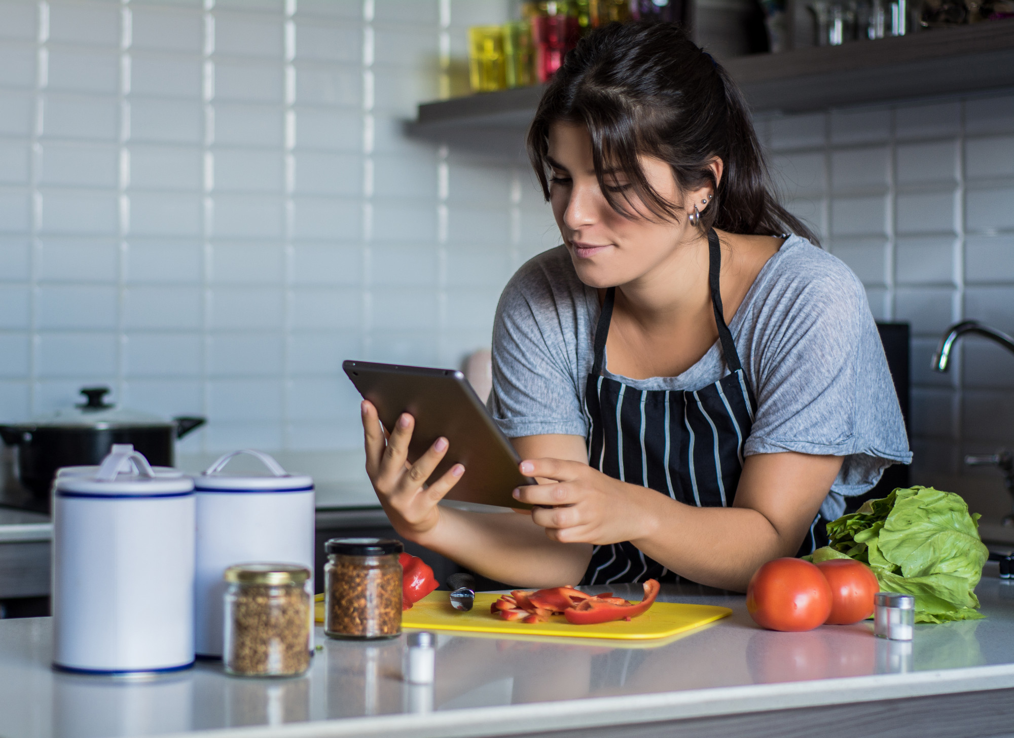 Studente che segue una lezione di cucina via tablet